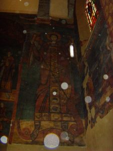 Ancient mural with religious figure and orbs.