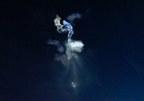 Smoke trails in dark night sky.