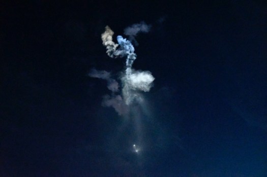 Smoke trails in dark night sky.