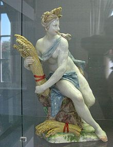 Porcelain statue of a wheat-holding figure.