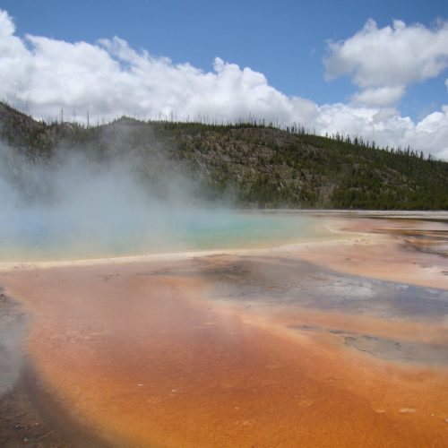 A hot spring with steam coming out of it.