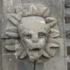 A stone face with sun rays on it.