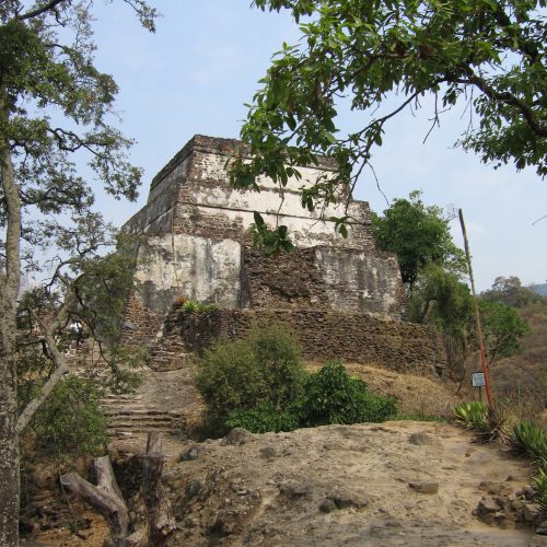A building on top of a hill with trees around it.