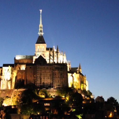 A castle like building with a spire on top of it.