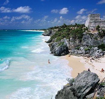 A beach with people swimming in the water.