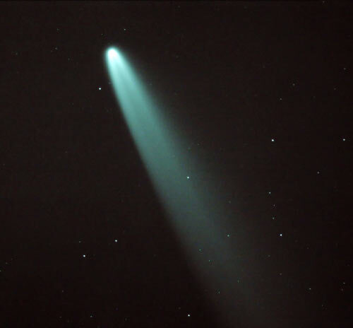 A green comet is seen in the sky.