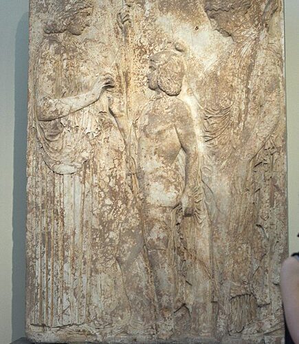 A stone slab with carvings of people and trees.