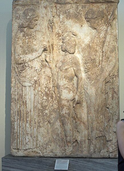 A stone slab with carvings of people and trees.