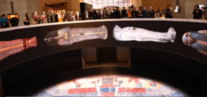 Museum exhibit with ancient Egyptian sarcophagi display.