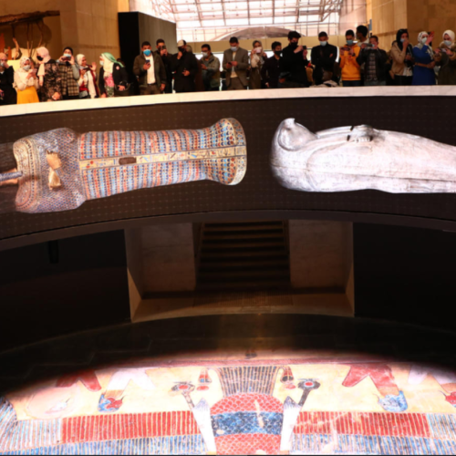 A group of people standing around in front of an exhibit.