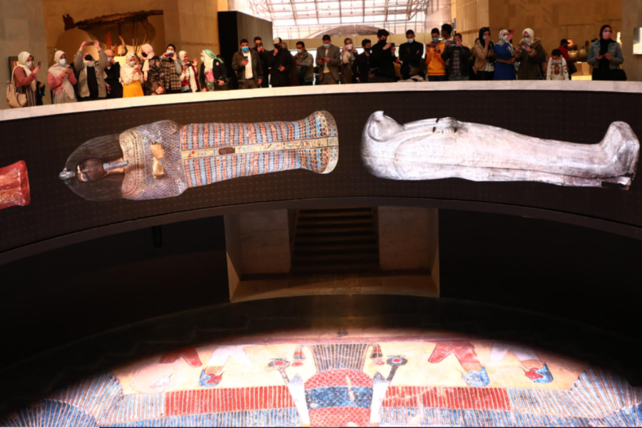 A group of people standing around in front of an exhibit.