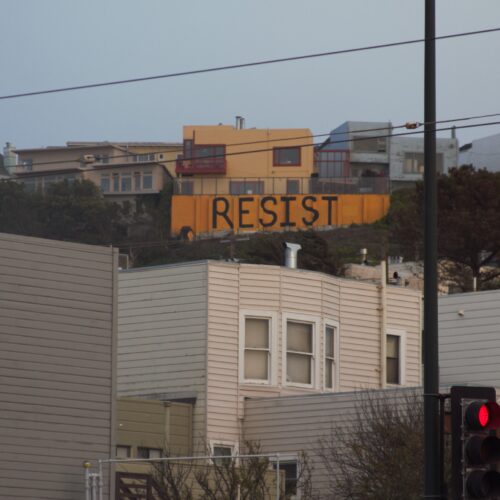 A sign that says resist on top of the building.