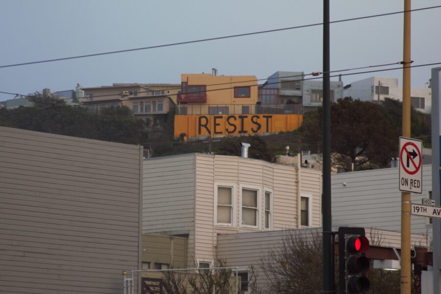 A sign that says resist on top of the building.