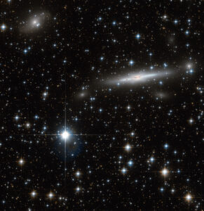Starry night sky with distant galaxies visible.