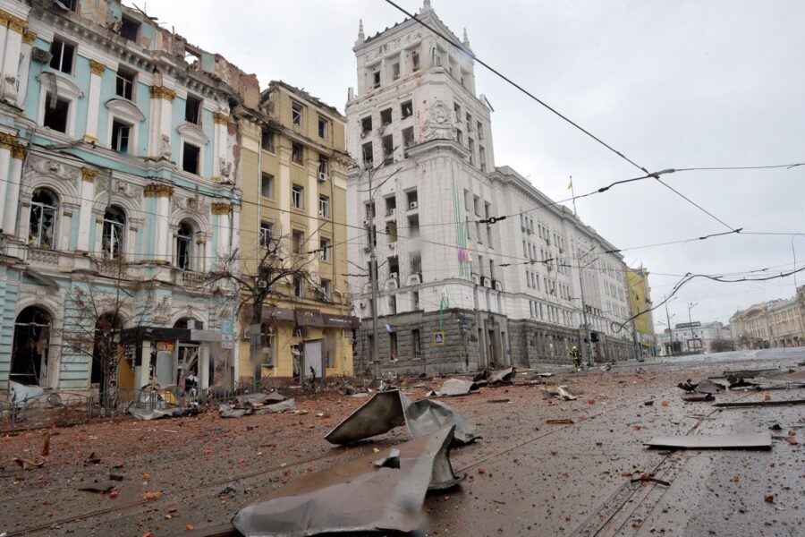 A street with buildings and rubble on the ground.