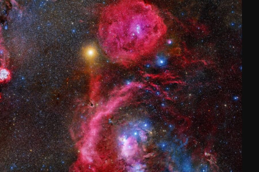 A red nebula with stars and nebulae in the background.