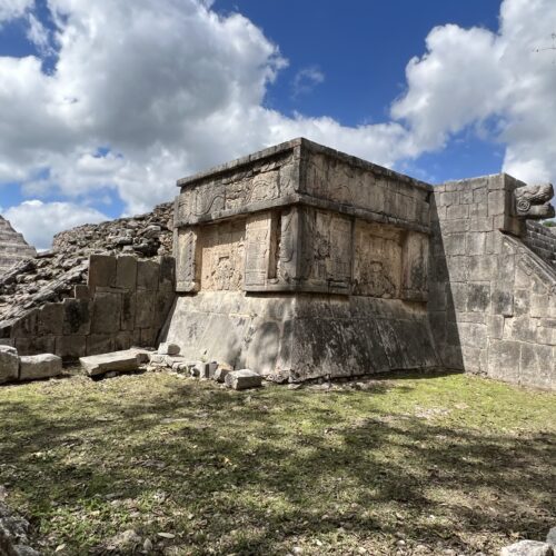 A stone structure with grass in the foreground.